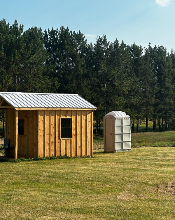 Grey Porta Potty for Sale Behind a Shed